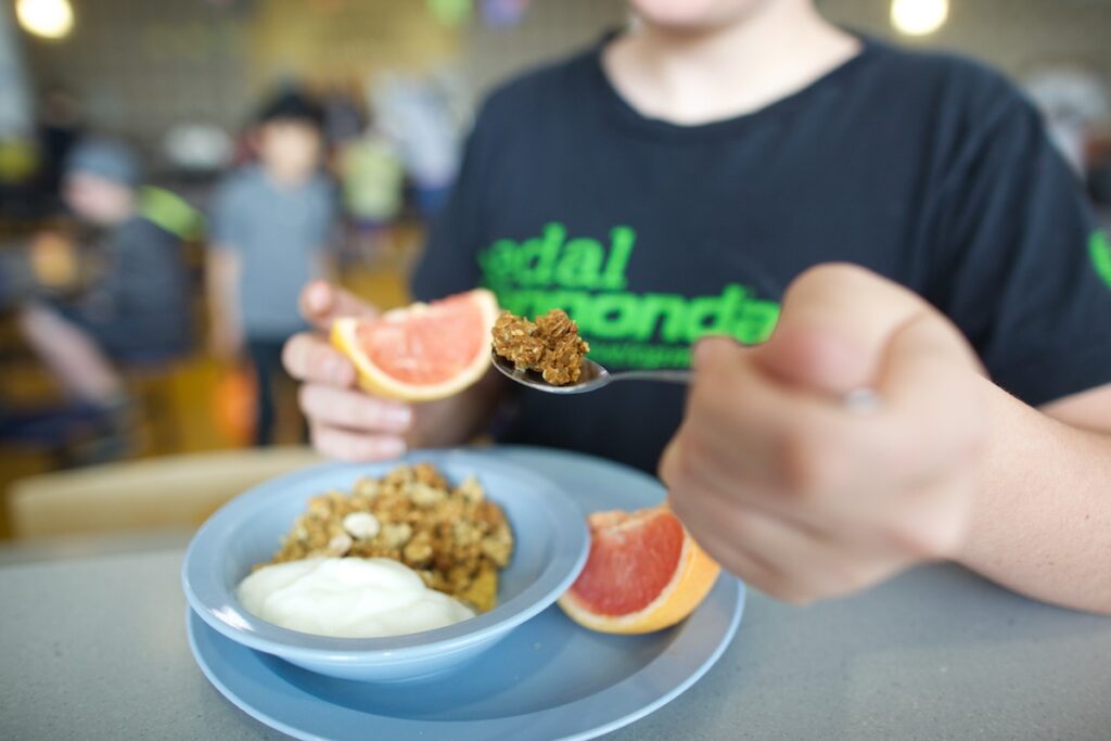 a kid with a grapefruit slice and Granola